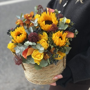 Композиция в сумке "Тональность" из подсолнухов, калл, ягод вибирнума, лимонных роз, скиммии и орхидеи в Жуковском